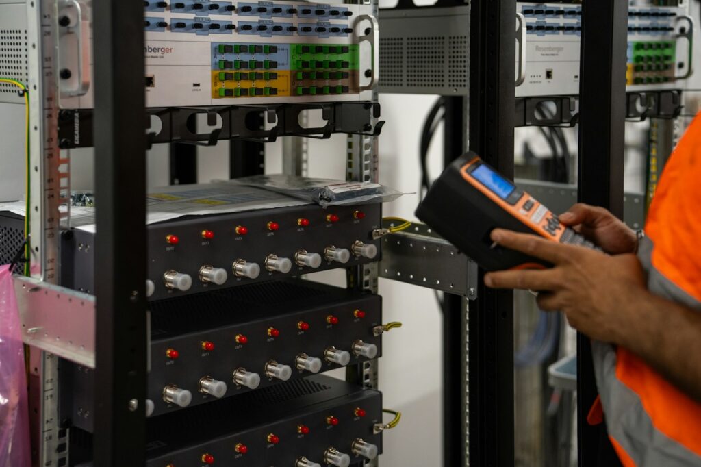 Técnico certificando pontos de rede em um rack com testador